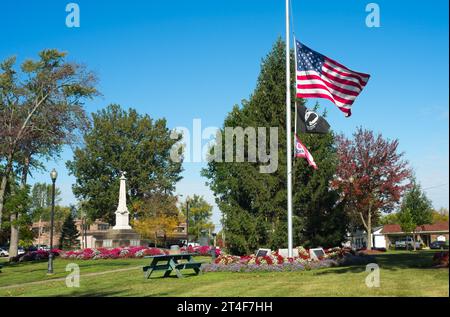 Eine US-Flagge fliegt auf halbem Personal mitten auf dem Stadtplatz in Twinsburg, Ohio Stockfoto