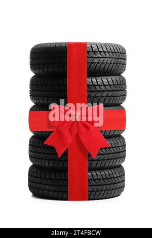 Studio-Aufnahme eines Haufens von Fahrzeugreifen mit rotem Schleife isoliert auf weißem Hintergrund Stockfoto
