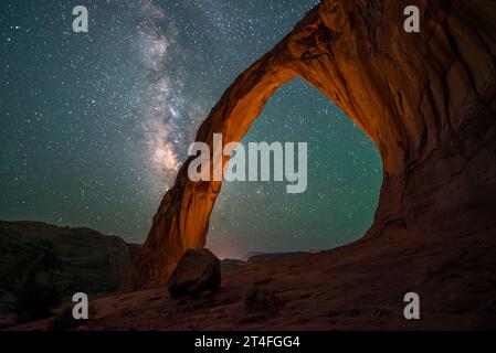 Man kann nicht umhin, einen Sternenhimmel im Schatten des Corona Arch, auch bekannt als Little Rainbow Bridge, in der Nähe von Moab, Utah, zu bestaunen. Stockfoto