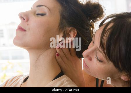 Nahaufnahme einer lateinischen erwachsenen Frau, Therapeutin-Ausbilder, Korrektur der Nackenhaltung ihrer Schülerin während Trainings- und Rehabilitationstherapie Stockfoto