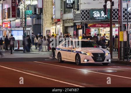 Tokio, Japan - 11. April 2023: Parken eines Taxis auf einer Stadtstraße im Stadtteil Shinjuku mit nicht identifizierten Personen. Der Stadtteil Shinjuku ist eine der wichtigsten Handelsmarken Stockfoto