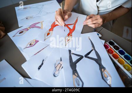 Eine gesichtslose Frau zeichnet Aquarelle von Sportbekleidung. Nahaufnahme der Hände eines Modedesigners. Stockfoto