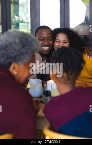 Glückliche afroamerikanische Familie, die zu Hause im dekorierten Speisesaal zu weihnachten zu Abend essen kann Stockfoto