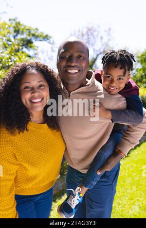 Porträt eines glücklichen afroamerikanischen Vaters, Mutter und Sohn, der sich im Garten umgibt, im Kopierraum Stockfoto