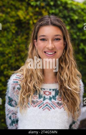 Porträt einer glücklichen kaukasierin mit langen blonden Haaren, die im Garten lächelt Stockfoto