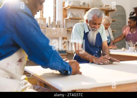 Zwei verschiedene männliche Töpfer Formen Ton mit Händen in Töpferstudio Stockfoto