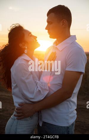 Romantische Beziehung zwischen dem schönen Mann und der Frau bei Sonnenuntergang Stockfoto