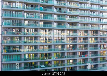 Modernes Glasgebäude mit Balkon. Wohnhaus und mit Haushaltsgegenständen bewohnt Wohngebäude. Vorderansicht Nahaufnahme Stockfoto