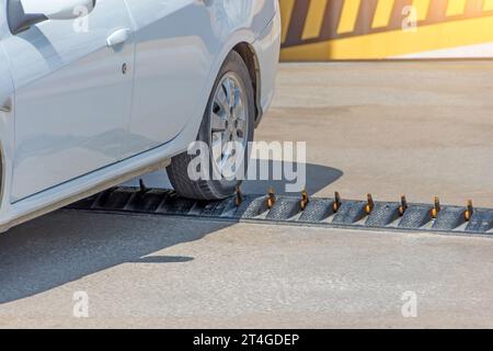 Stachel-Barrieren werden häufig verwendet, um einen Richtungsfluss auf einer einzigen Fahrspur zu erzwingen. Auto fährt vom Parkplatz ab Stockfoto