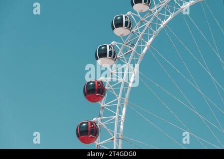 Rot-weiße Kabinen auf einem weißen Riesenrad gegen den Himmel Stockfoto