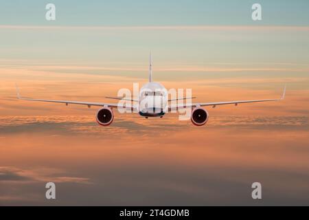 Passagiere Geschäftsflugzeug, das bei Sonnenuntergang über Wolken fliegt, gerade Sicht. Konzept für schnelles Reisen, Urlaub und Geschäft Stockfoto