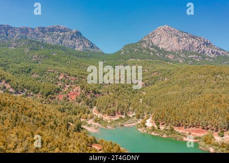 Blick aus der Vogelperspektive auf das Hochgebirge des Nationalparks. Holzsee-Reservoir-Wald zwischen felsigen Bergen und Gipfeln Stockfoto