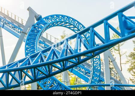 Achterbahn blau nach oben nach unten drehen und vorbeifahren, schleifen feint, spiralförmige Züge von Trolleys neigen dazu, nach unten zu fahren Stockfoto