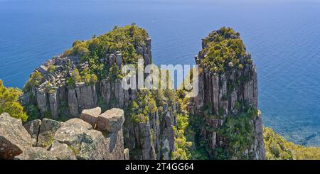 Bishop und Clerk, zwei Gipfel aus Doleritgestein von oben mit ruhigem blauem Ozean dahinter im Maria Island National Park, Tasmanien, Australien Stockfoto