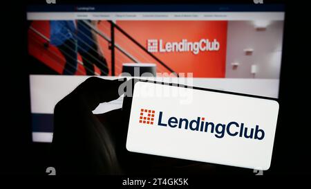 Person mit Smartphone und Logo des US-Finanzdienstleisters LendingClub Corporation vor der Website. Schwerpunkt auf dem Display des Telefons. Stockfoto