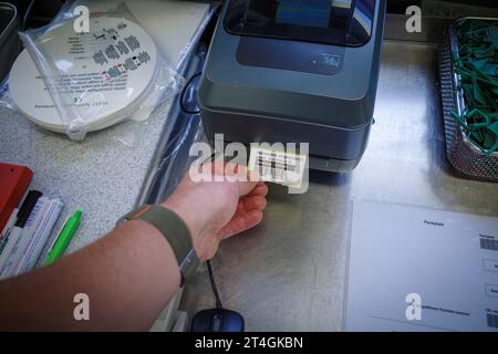 Ein Etikett wird aus einem Etikettendrucker herausgezogen Stockfoto