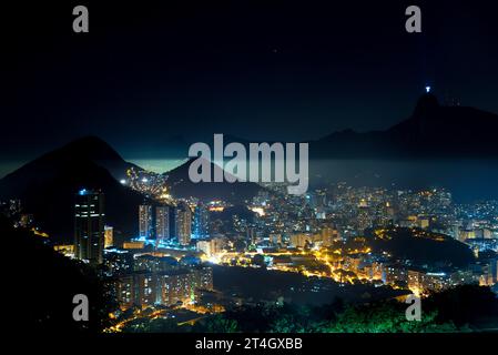 Corcovado Mountain und Botafogo Viertel in der Skyline von Rio de Janeiro bei Nacht vom Sugarloaf Mountain aus gesehen Stockfoto