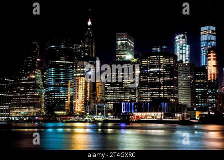 Nächtlicher Blick auf die bunte Skyline von Manhattan, die sich im East River spiegelt - Brooklyn, New York City Stockfoto