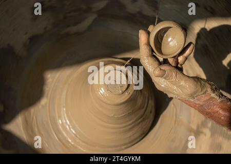 Indische Töpfer machen kleinen Topf oder Diya für Diwali mit Ton auf Töpferrad Handarbeit Stockfoto