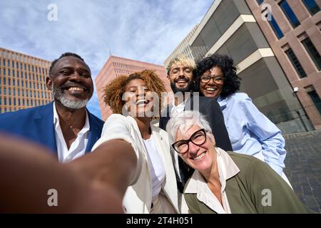 Glückliche Multi-ethnische Kollegen, die draußen ein Selfie machen Stockfoto
