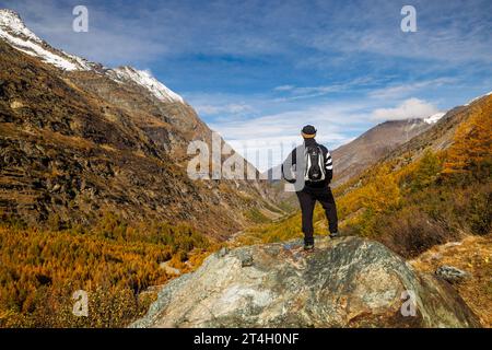 Wanderer genießt im Herbst den Blick über Saastal Stockfoto