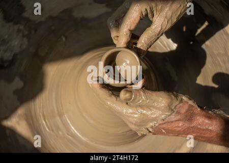 Indische Töpfer machen kleinen Topf oder Diya für Diwali mit Ton auf Töpferrad Handarbeit Stockfoto