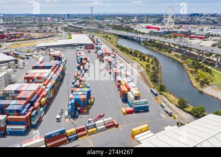 Aus der Vogelperspektive gestapelte Container auf einer Anlegestelle an einem Fluss in den Docklands in Melbourne, Victoria, Australien Stockfoto