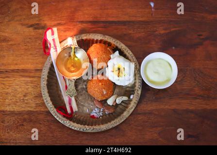 Kupferplatte gefüllt mit Rakhi und Süßigkeiten anlässlich von Raksha Bandhan aus oberem Winkel Stockfoto