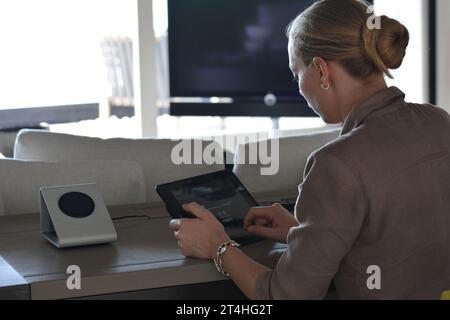 Seychellen, La Digue - 05. Oktober 2022: Frau, die zu Hause ein Tablet benutzt und auf den Bildschirm tippt Stockfoto