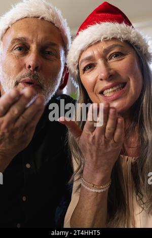 Glückliches weißes Ehepaar, das auf dem Sofa sitzt und zu Hause ein weihnachtsvideo anruft Stockfoto