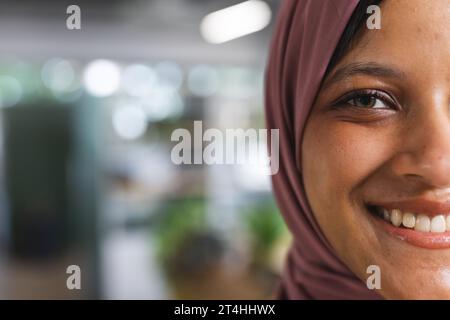 Porträt einer glücklichen birassischen Geschäftsfrau mit Hijab im kreativen Büro, Kopierraum Stockfoto