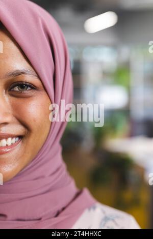 Porträt einer glücklichen birassischen Geschäftsfrau mit Hijab im kreativen Büro, Kopierraum Stockfoto