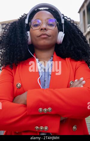 Eine Einzelaufnahme einer seriösen afroamerikanischen Geschäftsfrau, die mit überkreuzten Armen in die Kamera blickt. Stockfoto