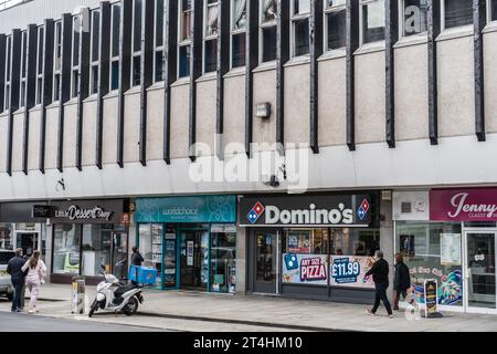 Shrewsbury, Shropshire, England, 1. Mai 2023. Leute laufen auf der Innenstadt mit Dominos Pizza zum Mitnehmen, Reisebüro und Dessertladen. Stockfoto