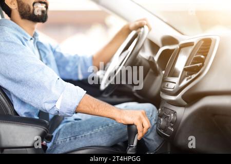 Beschnittener junger bärtiger Mann in zwangloser Fahrt mit einem netten Auto Stockfoto