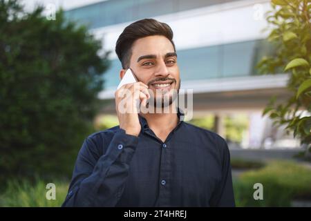 Arabischer Geschäftsmann, der draußen auf seinem Smartphone anruft und spricht Stockfoto