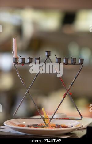 Unbeleuchtete und teilweise geschmolzene bunte Hanukka-Kerzen auf einer Menora während der Feier des jüdischen Lichterfestes in Israel. Stockfoto