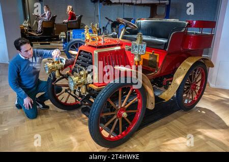 London, Großbritannien. 31. Oktober 2023. Ein Mitarbeiter mit einem 1901 Dürkopp 8 PS starken Zweizylinder-Tonneau im hinteren Bereich, geschätzt: £ 140.000 - £ 160.000, bei einer Vorschau für die Bonhams Cars Golden Age of Motoring Sale. Von den 31 im Angebot angebotenen Fahrzeugen sind 21 vor 1905 und berechtigt, am London to Brighton Vintage Car Run teilzunehmen. Der Verkauf findet am 3. November in den Bonhams New Bond Street Galeries statt. Quelle: Stephen Chung / Alamy Live News Stockfoto