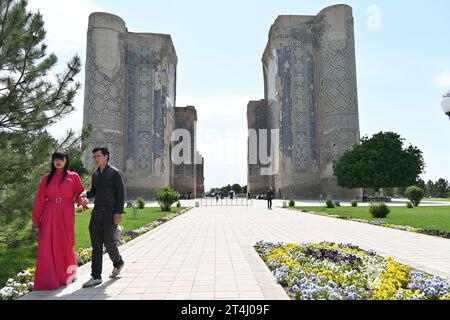 Usbekisches Paar in der Nähe der Doppelgebäude im Ak-Saray Palast in Shahrisabz, Usbekistan Stockfoto