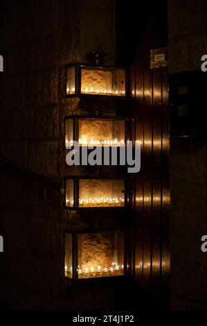 Glühende Hanukkah-Menorahs, beleuchtet mit kleinen Röhrchen mit Ölbrand in einem schützenden Glasgehäuse außerhalb eines Wohngebäudes in Jerusalem während der Feierlichkeiten Stockfoto