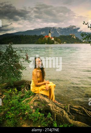 Frau in gelbem Kleid am Ufer des Bleder Sees, Slowenien IV Stockfoto