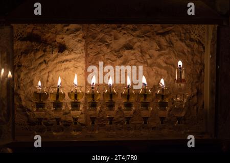 Eine Hanukka-Menora in Jerusalem, Israel, wo es traditionell ist, Öl in kleinen Glasfläschchen anstelle von Wachskerzen zu verbrennen, um die Feier des Th zu feiern Stockfoto