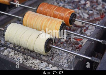 Das Mädchen rollt den Teig für süße Brötchen aus Stockfoto