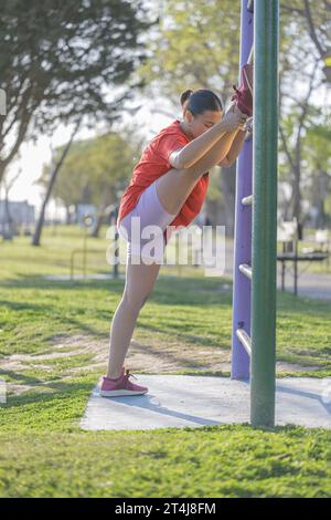 Lateinisches Mädchen, das in einem öffentlichen Park Beine streckt. Stockfoto