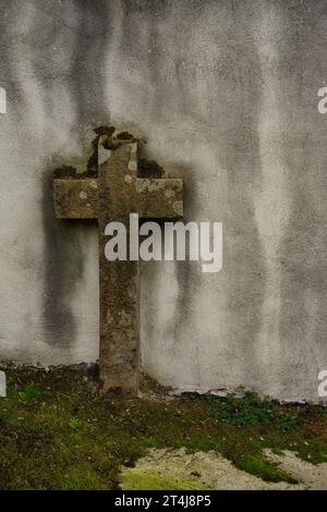 Steinkreuz auf einem Friedhof, um Beerdigungen, Einsamkeit, Introspektion, Spiritualität, Religion, Rituale, Allerheiligste oder jede Veranstaltung, die mit dem Geist in Zusammenhang steht Stockfoto