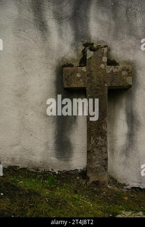 Steinkreuz auf einem Friedhof, um Beerdigungen, Einsamkeit, Introspektion, Spiritualität, Religion, Rituale, Allerheiligste oder jede Veranstaltung, die mit dem Geist in Zusammenhang steht Stockfoto