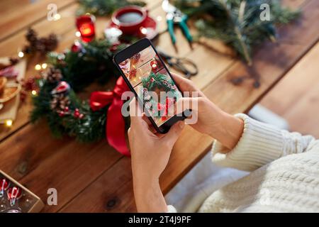 Hände mit Handy fotografieren weihnachtskranz Stockfoto