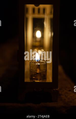 Eine leuchtende Hanukkah-Menora, die mit kleinen Ölröhrchen beleuchtet ist, brennt in einem schützenden Glasgehäuse vor einem Haus in Jerusalem während der Feier der Fes Stockfoto