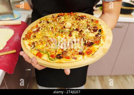 Rohe St. Pizza im Louis-Stil, hausgemacht auf hölzernem Hintergrund, mit Käse, Pfeffer, Speck, Zwiebeln Stockfoto