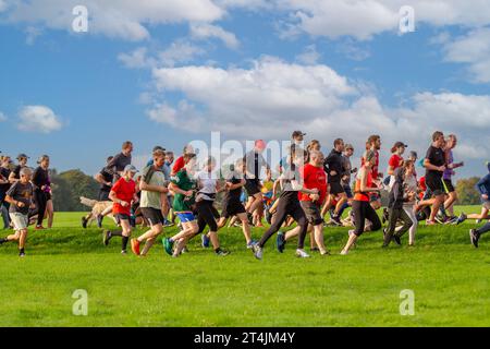 HARROGATE, YORKSHIRE, GROSSBRITANNIEN - 30. SEPTEMBER 2023. Eine Gruppe von Menschen unterschiedlichen Alters und Fähigkeiten, die gemeinsam bei einem UK Parkrun-Event in einem Park laufen Stockfoto